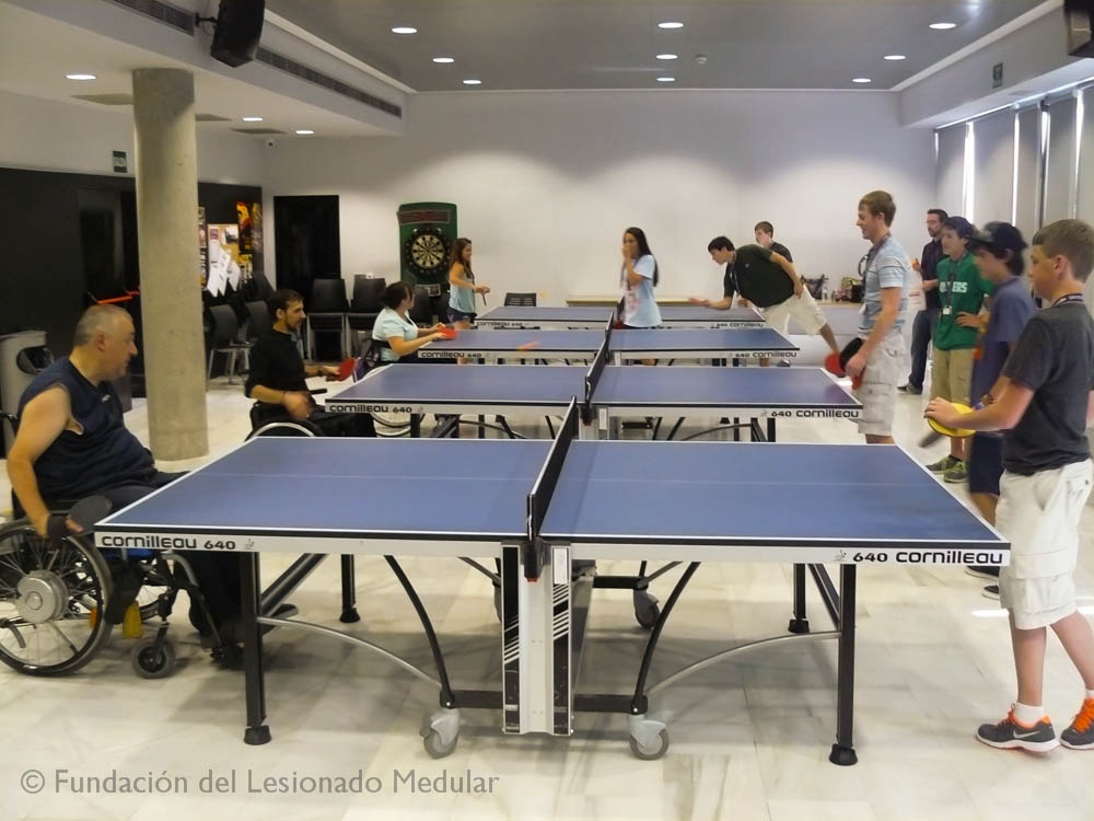 Jóvenes fundación people to people junto a usuarios de la fundación lesionado medular jugando a tenis de mesa